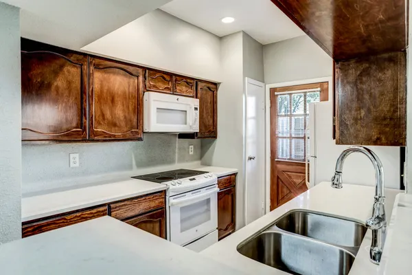 a kitchen with stainless steel appliances granite countertop a sink and a refrigerator