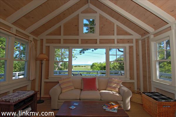 a living room with patio furniture and a floor to ceiling window
