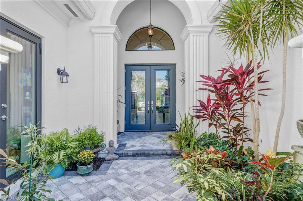 a view of a entryway door with potted plants in front of house