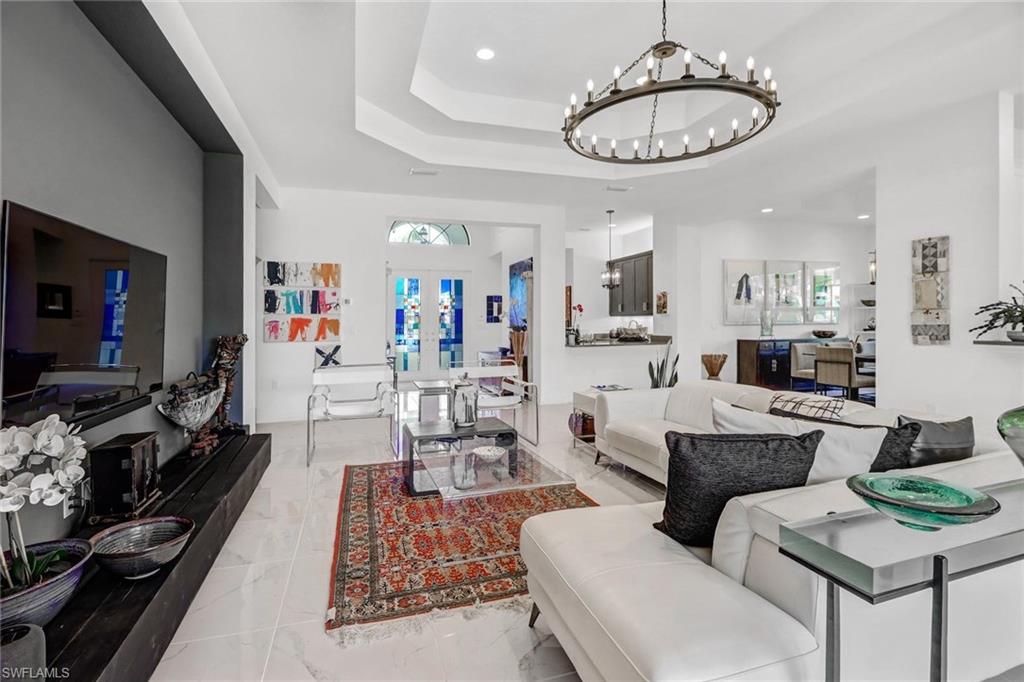 4617 Azalea Drive Naples, FL 34119 - Photo 11 of 34 a living room with furniture a dining table and a fireplace