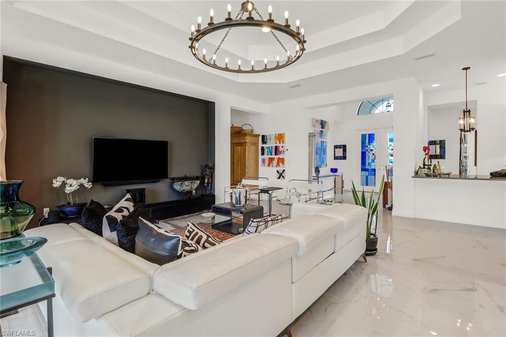4617 Azalea Drive Naples, FL 34119 - Photo 12 of 34 a living room with furniture a flat screen tv and a large window