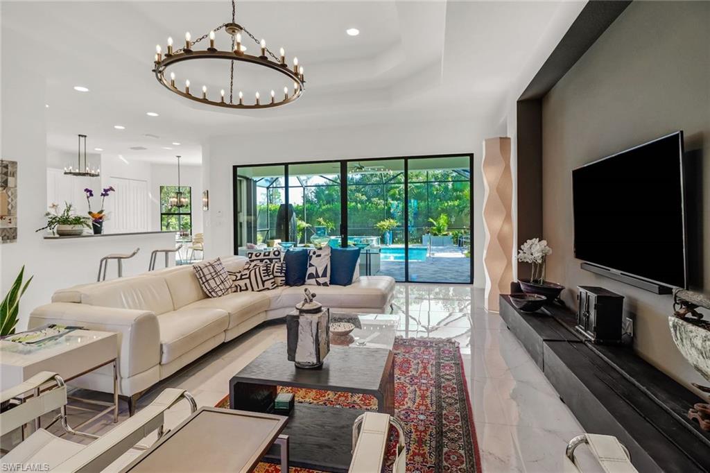 4617 Azalea Drive Naples, FL 34119 - Photo 13 of 34 a living room with furniture flat screen tv and a large window