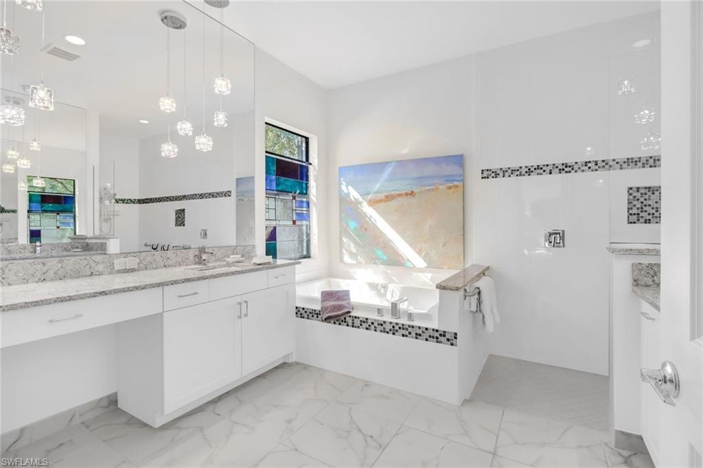 4617 Azalea Drive Naples, FL 34119 - Photo 15 of 34 a spacious bathroom with a granite countertop sink a mirror and a bathtub