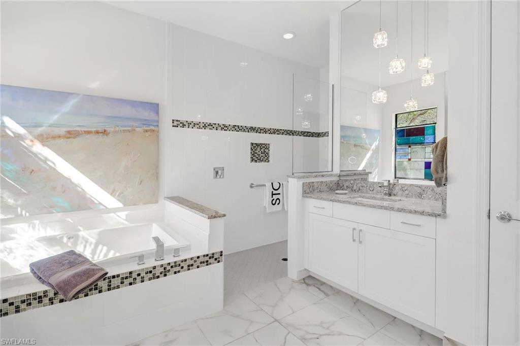 4617 Azalea Drive Naples, FL 34119 - Photo 16 of 34 a bathroom with a granite countertop sink and a mirror