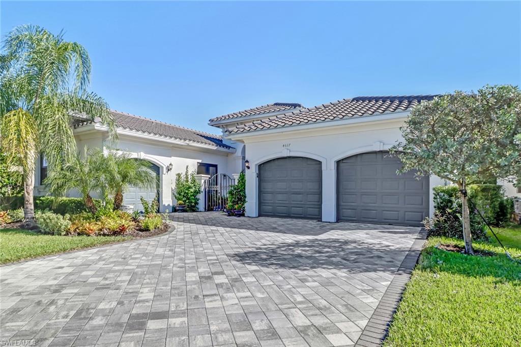 4617 Azalea Drive Naples, FL 34119 - Photo 2 of 34 a front view of a house with a yard and garage