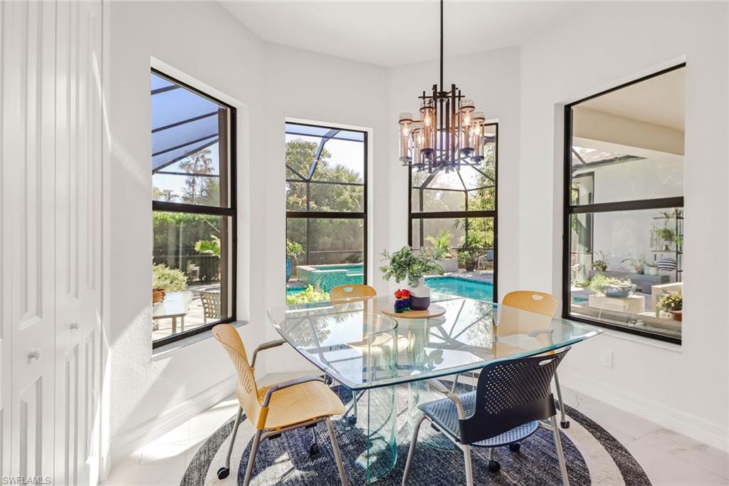 4617 Azalea Drive Naples, FL 34119 - Photo 10 of 34 a dining room with furniture a chandelier and wooden floor
