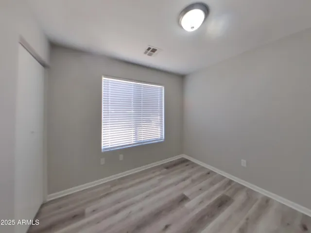 a view of a hallway with wooden floor and windows