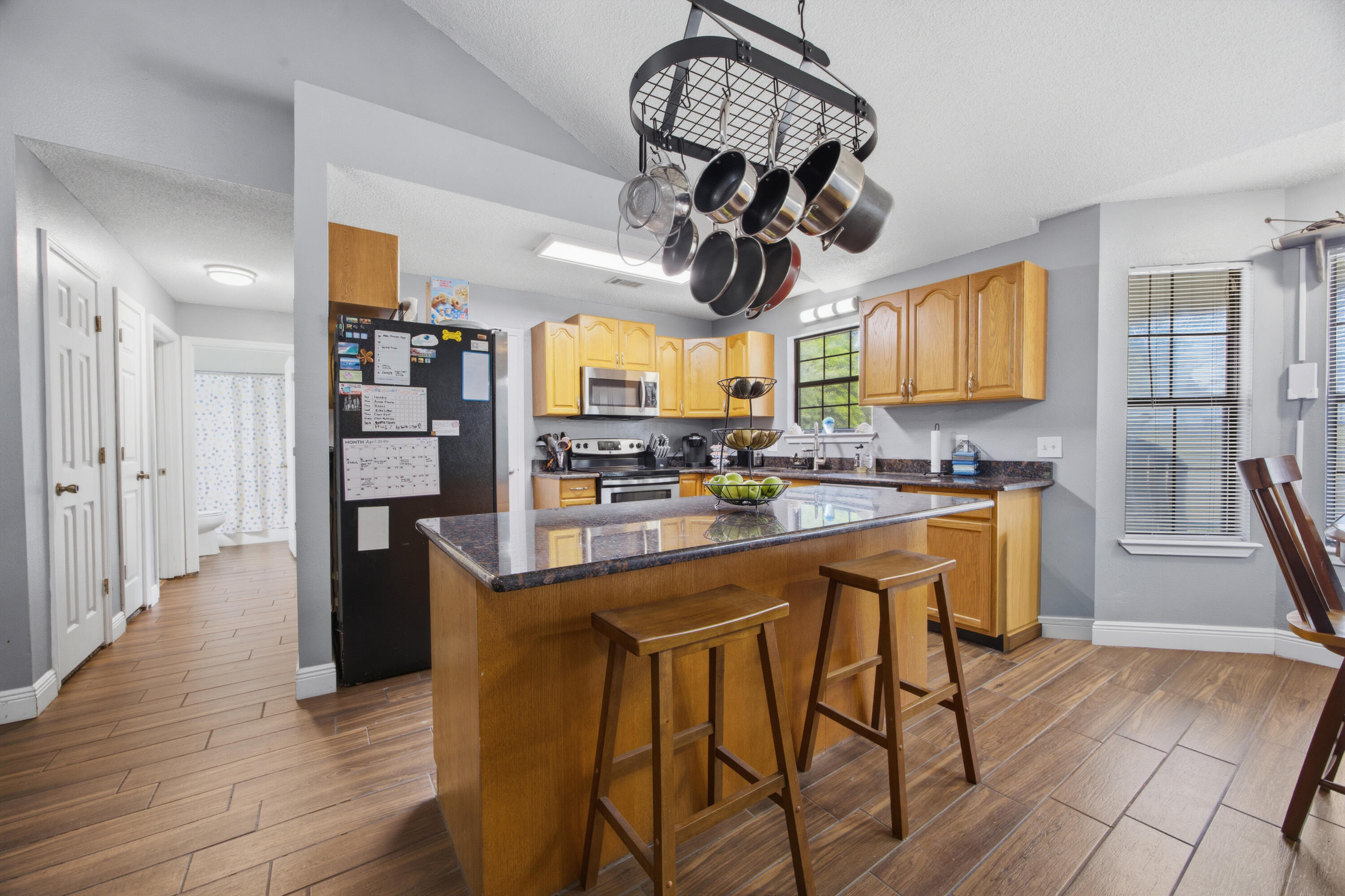 3494 Highway 90 Crestview, FL 32539 - Photo 13 of 71 a kitchen with stainless steel appliances granite countertop wooden floors a stove and a chandelier