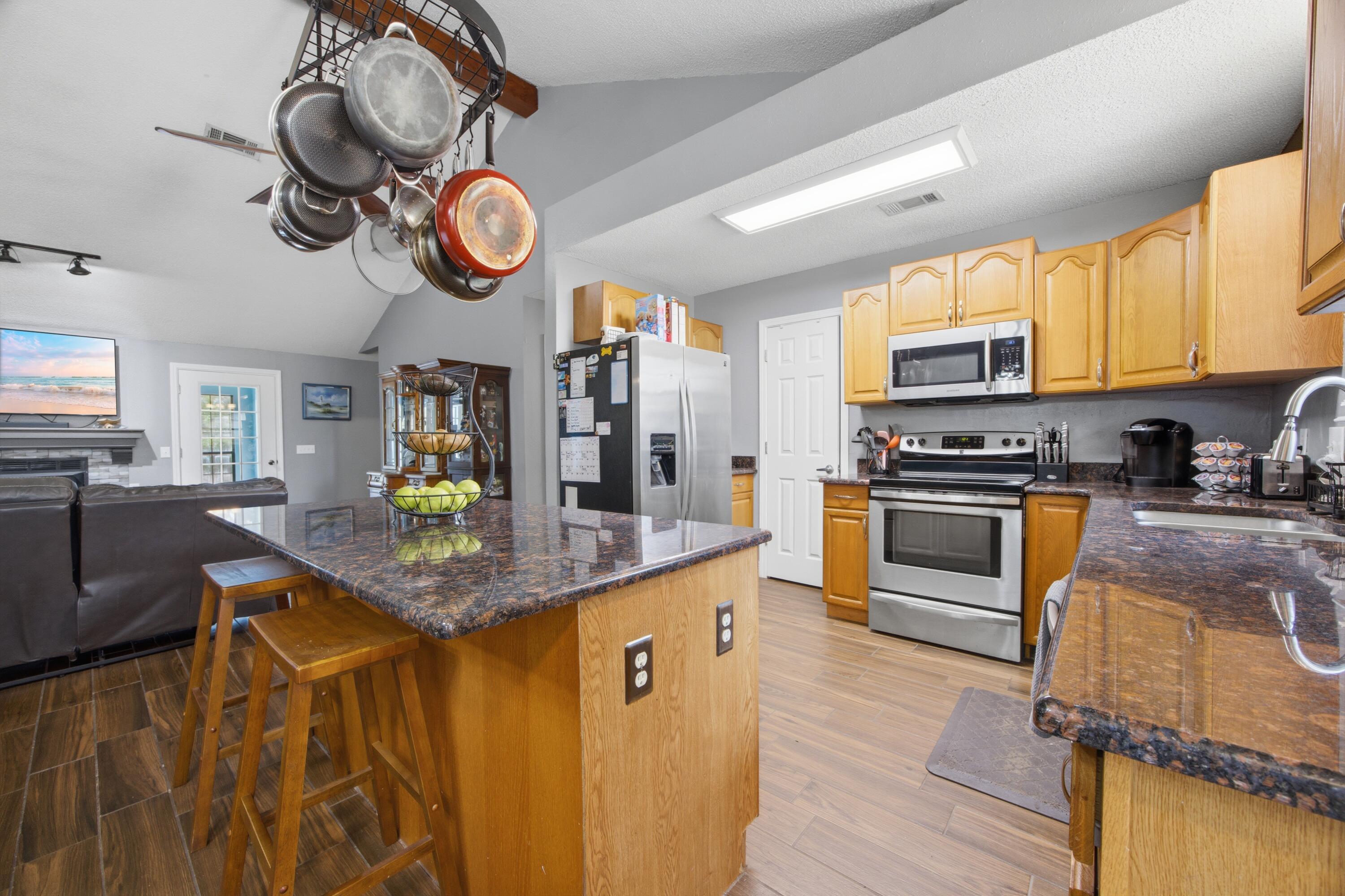 3494 Highway 90 Crestview, FL 32539 - Photo 6 of 71 a kitchen with stainless steel appliances granite countertop a sink a stove top oven a chimney cabinets and wooden floor