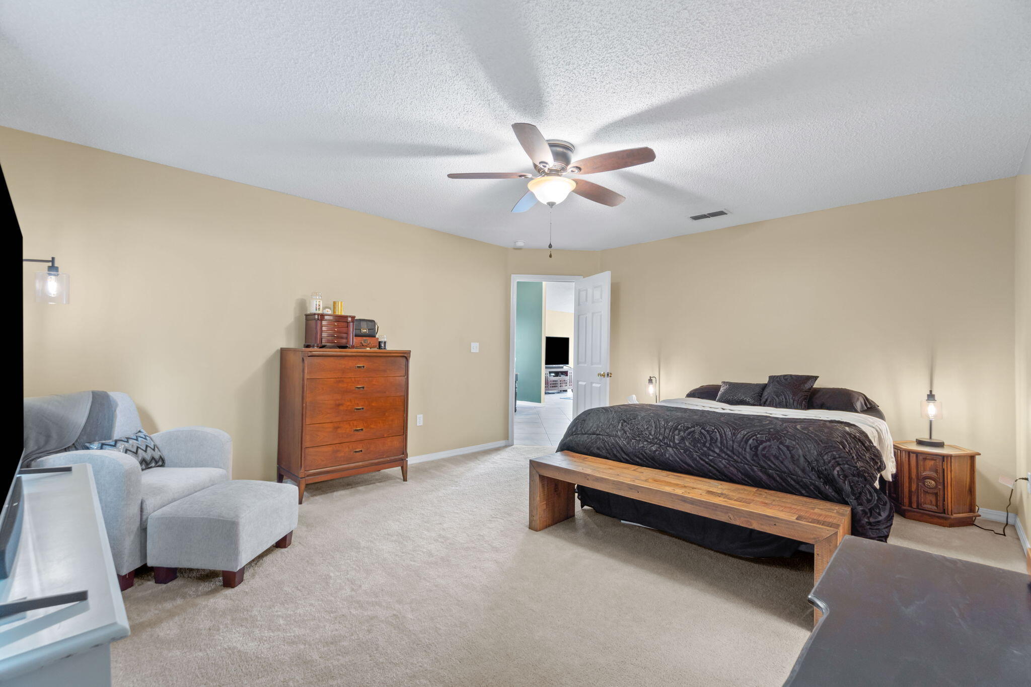 246 Limestone Circle Crestview, FL 32539 - Photo 18 of 27 a spacious bedroom with a bed and a chandelier