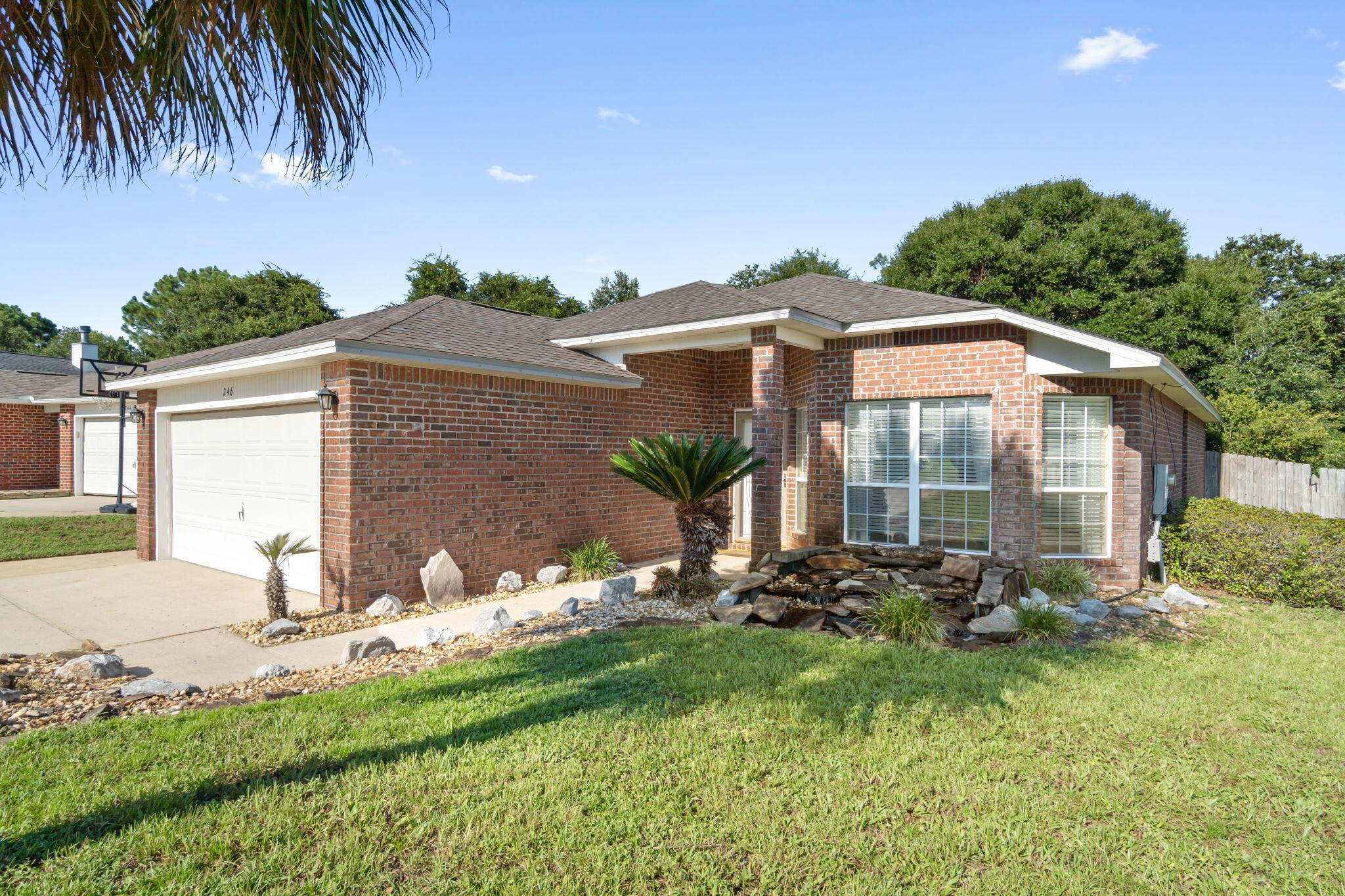 246 Limestone Circle Crestview, FL 32539 - Photo 2 of 27 a backyard of a house with table and chairs under an umbrella