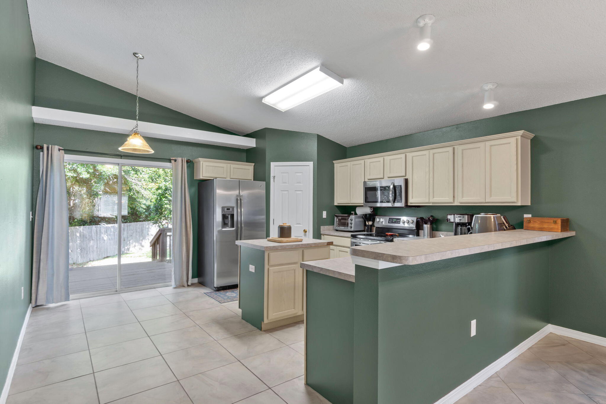 246 Limestone Circle Crestview, FL 32539 - Photo 8 of 27 a kitchen with stainless steel appliances granite countertop a refrigerator a sink a stove top oven and a view of living room