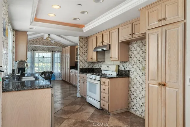 a kitchen with stainless steel appliances granite countertop a stove a sink and a refrigerator