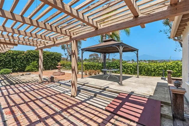 a view of a patio with a table and chairs under an umbrella