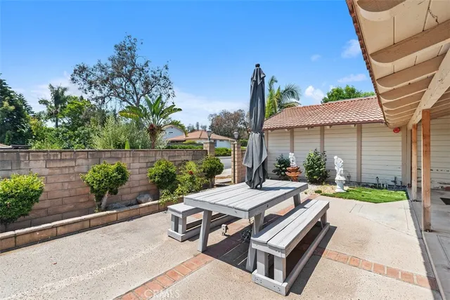 a view of a patio with couches table and chairs under an umbrella