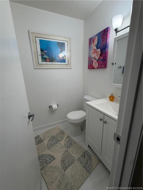 1225 Northwest 21st Street, Unit 7705 Stuart, FL 34994 - Photo 12 of 28 a bathroom with a toilet a sink and a mirror