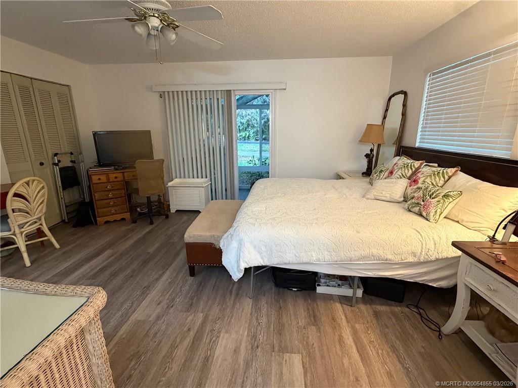 1225 Northwest 21st Street, Unit 7705 Stuart, FL 34994 - Photo 17 of 28 a bedroom with a bed and wooden floor