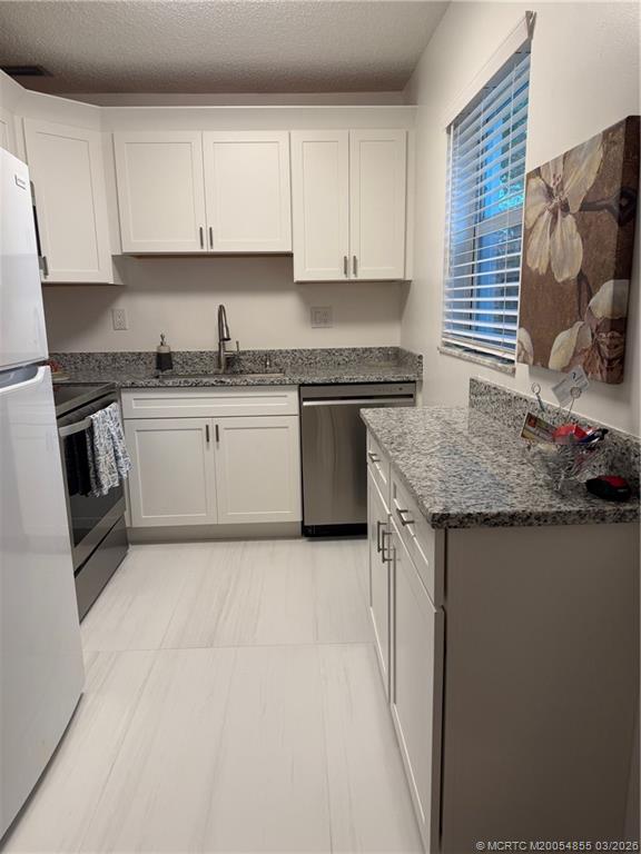 1225 Northwest 21st Street, Unit 7705 Stuart, FL 34994 - Photo 8 of 28 a kitchen with granite countertop a sink and a stove