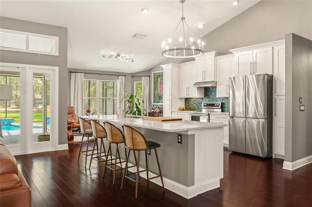 133 Ross Lake Lane Sanford, FL 32771 - Photo 7 of 32 a kitchen with stainless steel appliances a dining table chairs and wooden floor