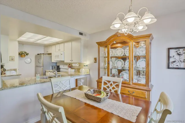 a view of a dining room with furniture a chandelier and a window