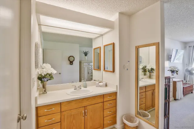 a bathroom with a granite countertop sink a mirror and a shower