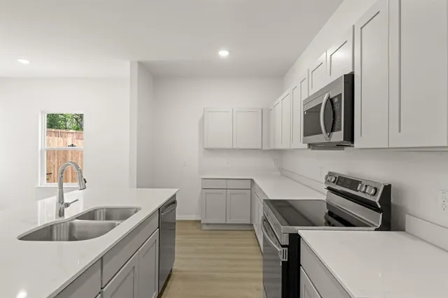 a kitchen with a sink cabinets and stainless steel appliances