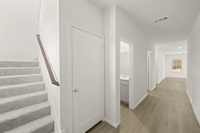 a view of a hallway with wooden floor and entryway