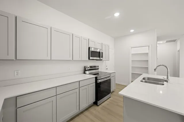 a kitchen with a sink stainless steel appliances and cabinets