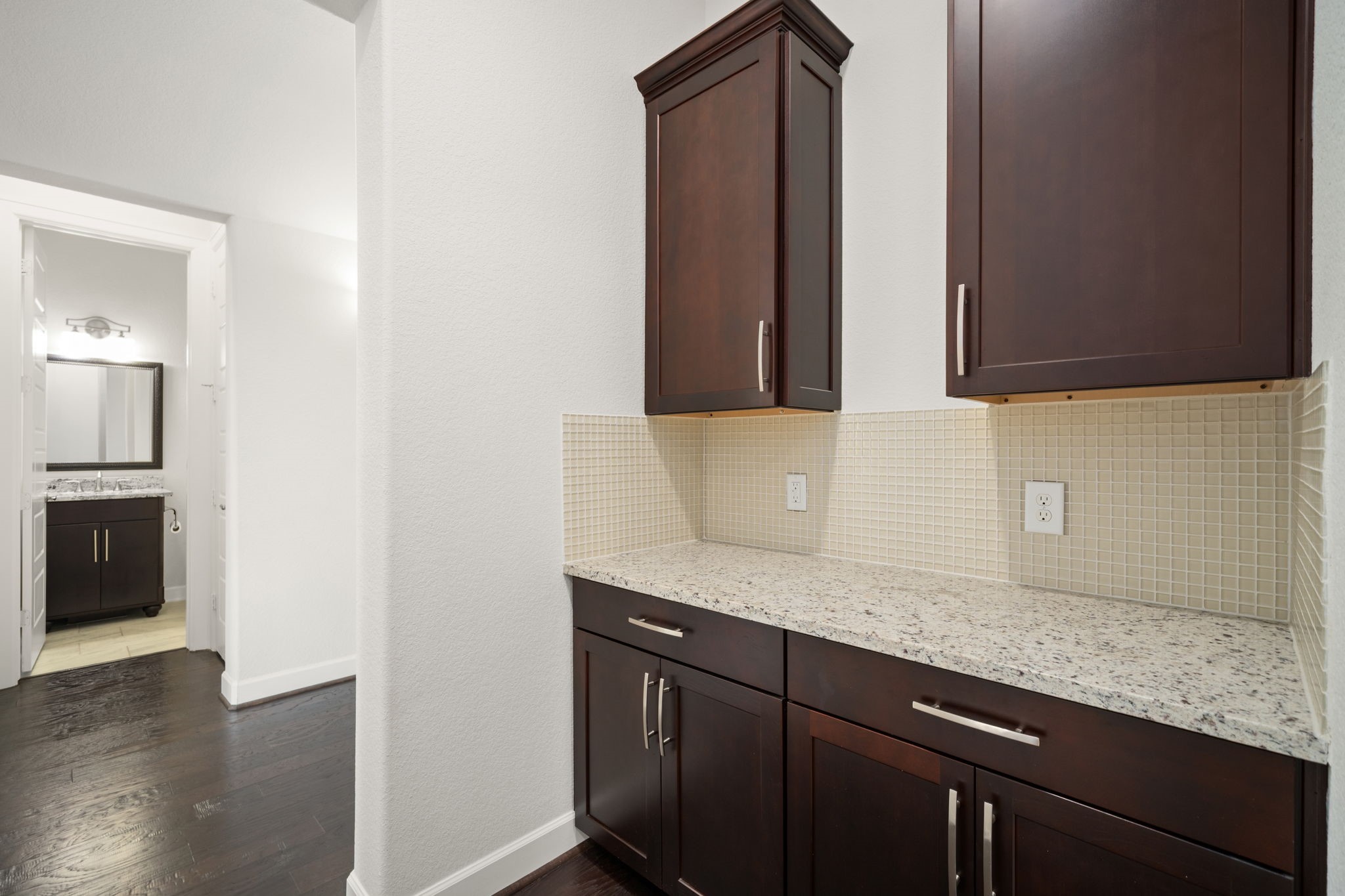 3622 Sage Hollow Drive Spring, TX 77386 - Photo 14 of 46 The elegant butler's pantry area offers the perfect staging zone for formal dinners, complete with a matching granite countertop, dedicated storage cabinets, and a refined tile backsplash.