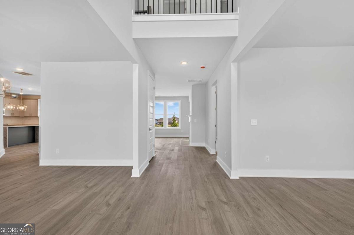 120 Patillo Manor, Unit 5 Stockbridge, GA 30281 - Photo 2 of 3 a view of a hallway with wooden floor and a refrigerator