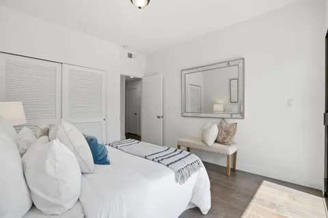 a bedroom with a bed and a large mirror