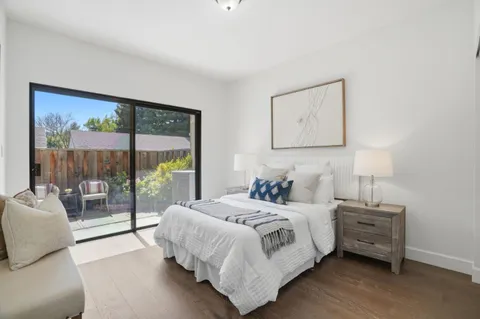 a living room with furniture a flat screen tv and a floor to ceiling window