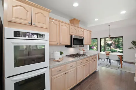 a kitchen with stainless steel appliances a sink stove top oven and cabinets