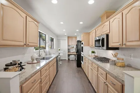 a kitchen with stainless steel appliances granite countertop a stove a sink and a refrigerator