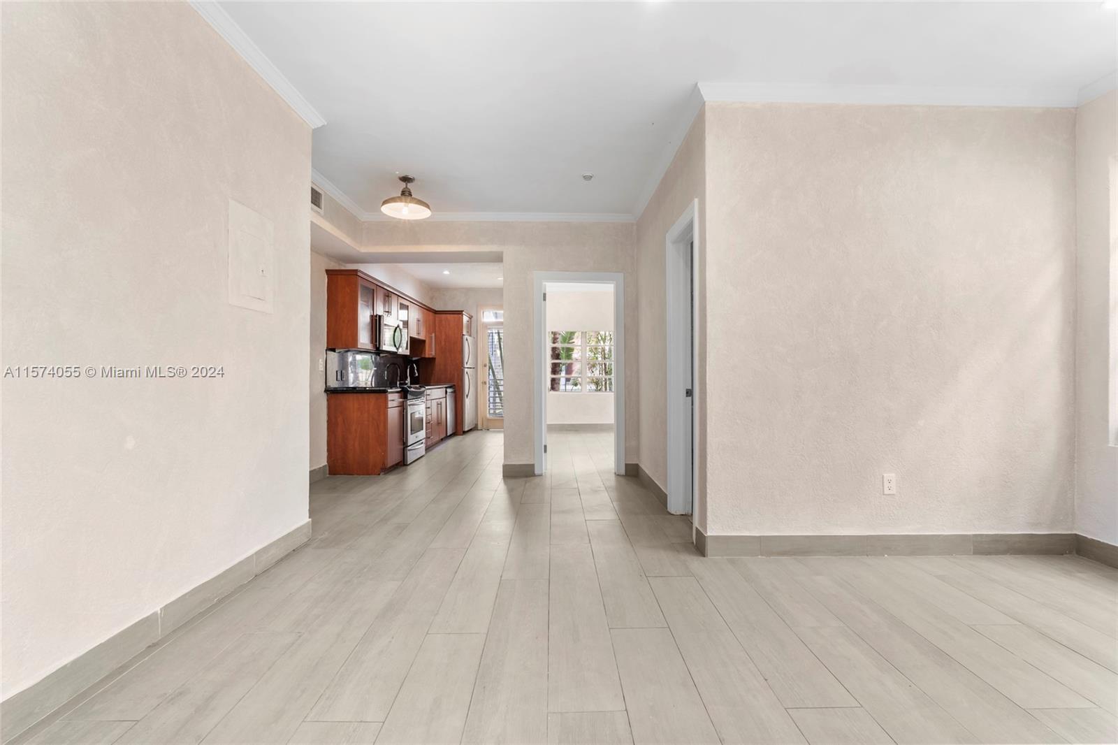 934 16th Street, Unit 5 Miami Beach, FL 33139 - Photo 2 of 22 a view of a hallway with wooden floor and a living room