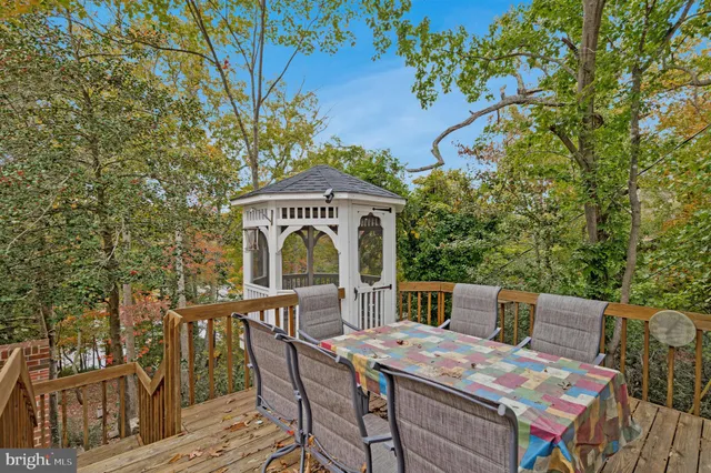a roof deck with table and chairs and potted plants