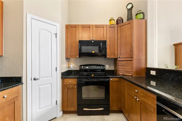 a kitchen with stainless steel appliances granite countertop a refrigerator a stove and a sink