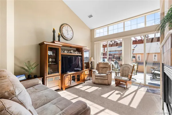 a living room with furniture a flat screen tv and a fireplace