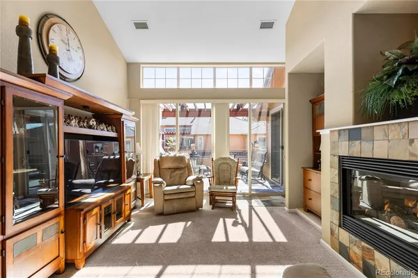 a living room with furniture a fireplace and kitchen view
