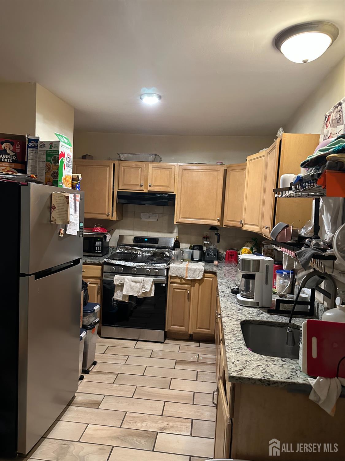 2 Ball Street New Brunswick, NJ 08901 - Photo 7 of 18 a kitchen with a sink stainless steel appliances and white cabinets