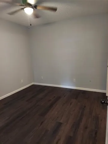 a view of an empty room with a chandelier fan