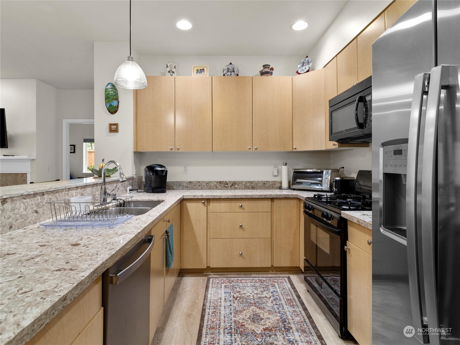 5100 Talbot Place South, Unit A Renton, WA 98055 - Photo 5 of 15 a kitchen with stainless steel appliances granite countertop a sink a stove and a refrigerator
