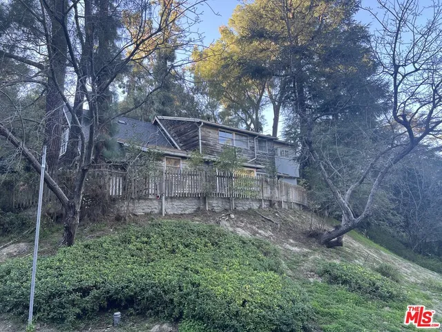 a backyard of a house with lots of green space and wooden fence