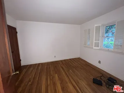 a view of a room with wooden floor and windows