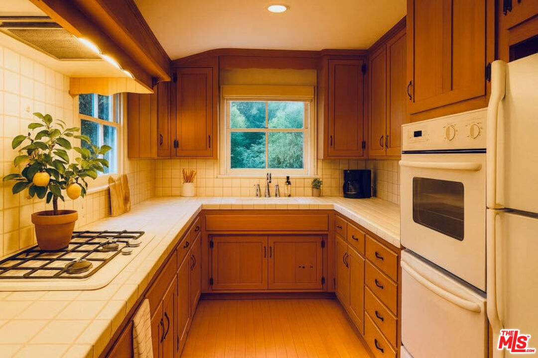 14807 Round Valley Drive Sherman Oaks, CA 91403 - Photo 2 of 25 a kitchen with a stove a sink and a refrigerator