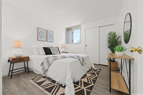 a bedroom with a bed a potted plant and a potted plant