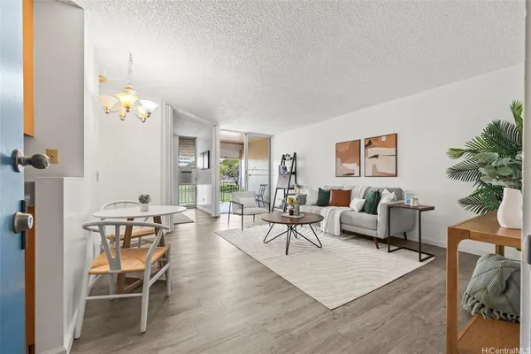 a living room with furniture a chandelier and a dining table