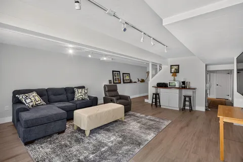a living room with furniture and view of kitchen