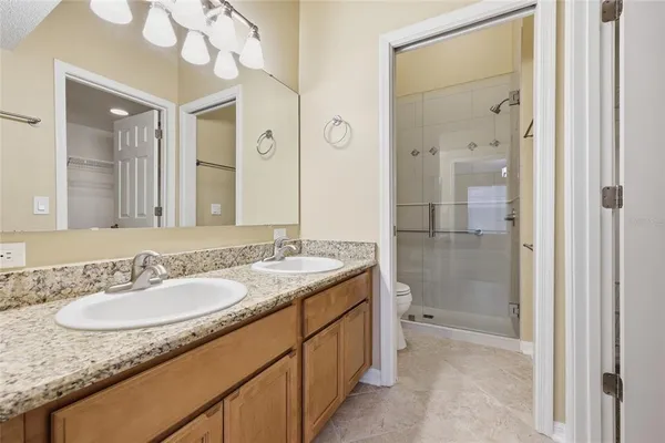 a bathroom with a granite countertop sink a mirror and a shower