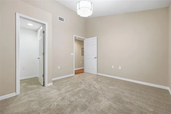 an empty room with wooden floor and mirror
